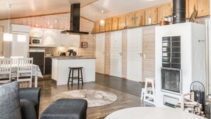 Een moderne keuken met witte kasten, een centraal eiland en een zwarte kookplaat.
