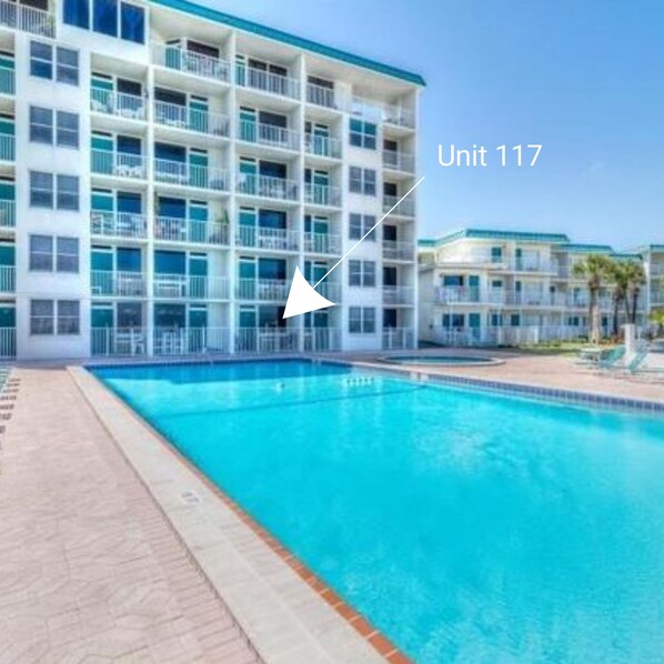 Een hotelgebouw met een zwembad, aangeduid als Unit 117.