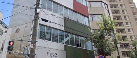 A multi-story building with signage for 'TAMA' and 'TSUK'.