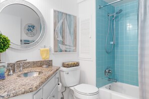 Une salle de bain avec un lavabo, des toilettes et une douche.