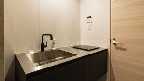 A modern bathroom with a stainless steel sink, a black faucet, and a bottle of hand soap. - Grand Base Nagasaki City (Nagasaki)
