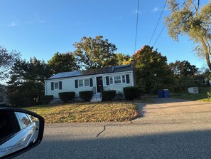 A single-story house with a front porch, a small front yard, and a driveway.