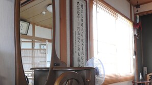 A traditional Japanese room with tatami flooring, a wooden chair, a large mirror, and a shoji screen. - Asahikawa Big House 10 People (Asahikawa)