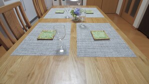 A dining table with placemats, wine glasses, and a vase with flowers. - Okazaki House up to 8 People (Okazaki)