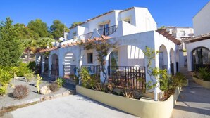 A two-story building with a white facade, arched windows, and a balcony with a metal railing. - Imperial Park by Interhome (Calpe/Calp)