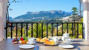 A table set for breakfast with a mountain view, including a mountain and a village in the background. - Imperial Park by Interhome (Calpe/Calp)