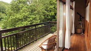 A balcony with a wooden railing, a wicker chair, and a telescope. - Kougetsu Sanso (Hachioji)