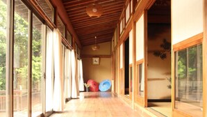A corridor with wooden flooring, large sliding glass doors, and traditional Japanese sliding doors. - Kougetsu Sanso (Hachioji)