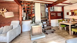 Ein gemütlicher Wohnbereich mit einer Couch, einem Esstisch und einer Treppe.