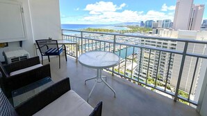 Un balcón con vista a un puerto deportivo y al paisaje urbano.