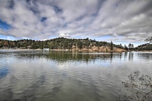 Un lago tranquilo con una ladera boscosa al fondo.