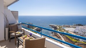 Un balcón con muebles de mimbre, vista al océano y zona de resort costera.
