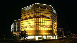 A multi-story building with illuminated windows and signage. - Yokohama Minamimirai Manyo-Club (Yokohama)