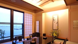 A traditional Japanese-style room with tatami flooring, a low table, and a view of the sea. - Yokohama Minamimirai Manyo-Club (Yokohama)