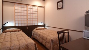 A room with two beds, a desk with a computer, and a TV. - Yokohama Minamimirai Manyo-Club (Yokohama)