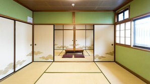 A traditional Japanese room with tatami flooring, sliding doors, and a low wooden bench. - Yoshikou (Takahama)