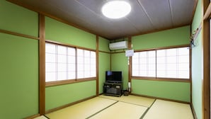 A traditional Japanese room with tatami flooring, a television, and a small cabinet. - Yoshikou (Takahama)