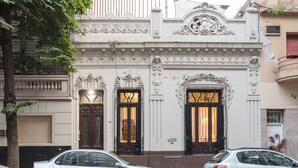 Ein Gebäude mit aufwendigen architektonischen Details, darunter dekorative Verzierungen und ein prachtvoller Eingang.