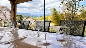 An outdoor dining area with a table, chairs, and wine glasses. - Mitsuba House (Annaka)