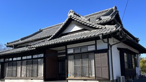 A traditional Japanese building with a tiled roof, large windows, and a wooden entrance. - Mitsuba House (Annaka)