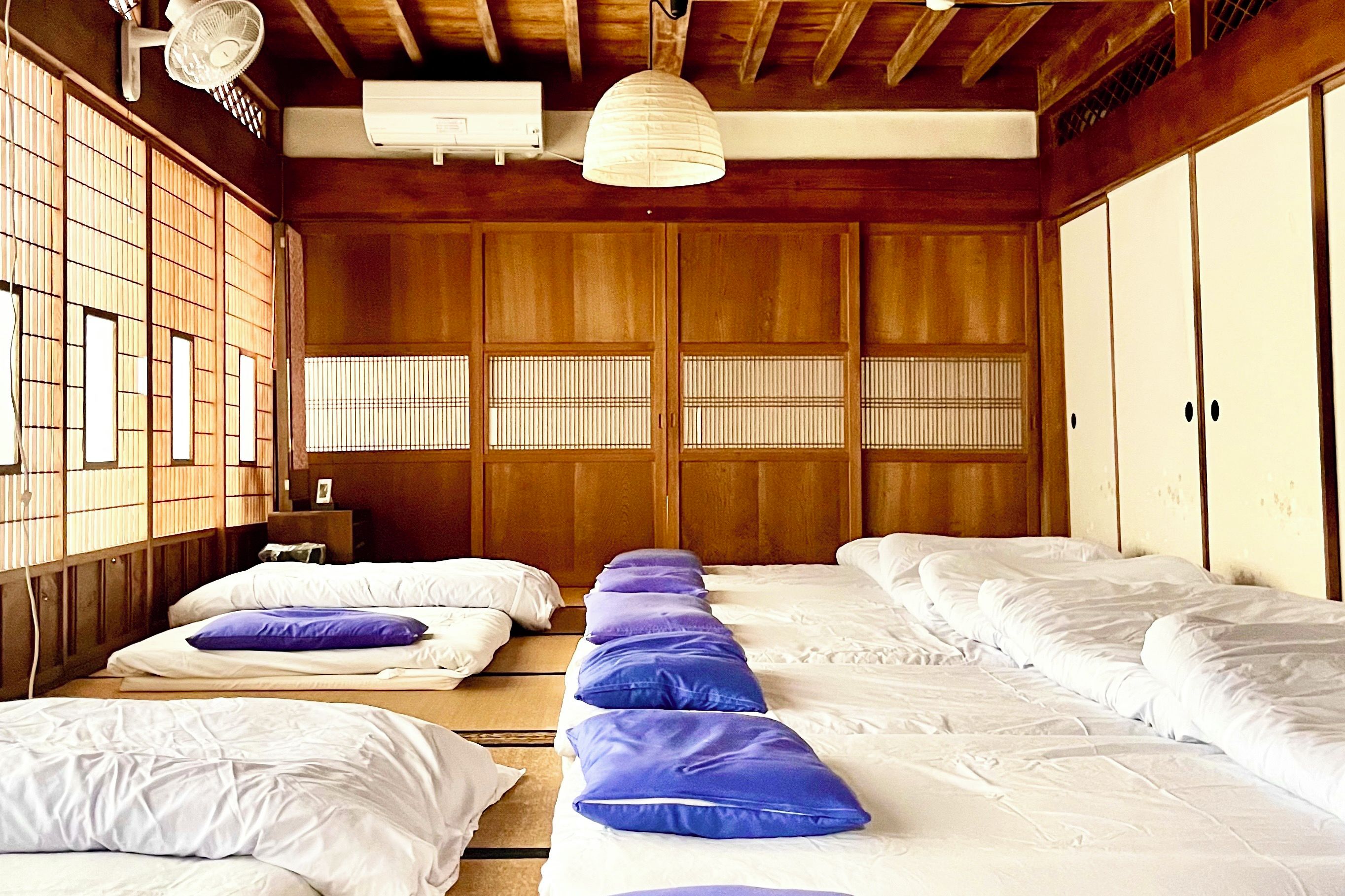 Ein traditioneller japanischer Raum mit Tatami-Böden, Holzschiebetüren und einem Deckenventilator.
