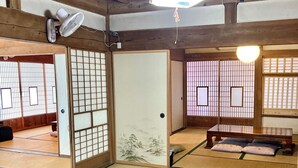 Um quarto japonês tradicional com tatames, uma mesa de madeira baixa e biombos shoji.