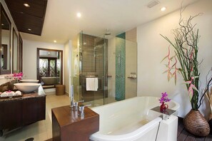 Un bagno moderno con una vasca freestanding, una cabina doccia in vetro e un mobile lavabo con un lavandino grande.