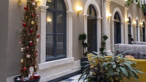 A building facade with arched windows, a Christmas tree, and potted plants. - Ferman Port Hotel - Special Class (Istanbul)
