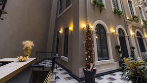 A spacious atrium with a checkered floor, large potted plants, and a Christmas tree. - Ferman Port Hotel - Special Class (Istanbul)