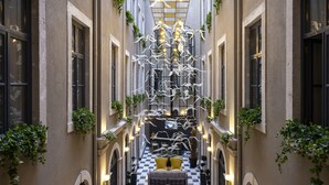 A narrow corridor with a checkered floor, white hanging decorations, and seating areas with cushions. - Ferman Port Hotel - Special Class (Istanbul)
