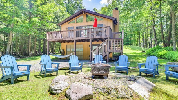 Une cabane dotée d’une terrasse, d’un espace salon extérieur et d’un foyer.