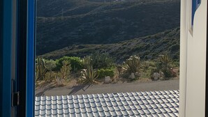 A view through an open door of a building with a tiled roof and a mountainous landscape in the background. - Appart 4/6 people sea and mountain view, outdoor and inter heated swimming pool (Peniscola)