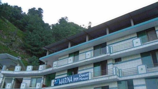 A multi-story building with a sign reading "MARINA Inn House". - Marina Inn Guest House (Abbottabad)