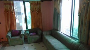 A living room with a sofa, two armchairs, and a patterned floor. - Marina Inn Guest House (Abbottabad)