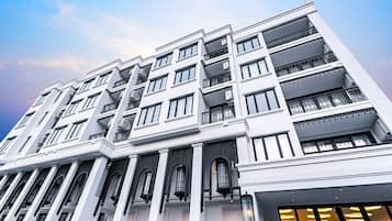A multi-story hotel with a modern architectural design, featuring balconies and large windows.