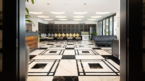 A lobby with a checkered floor, seating area, and a reception desk. - Glory Boutique Suite (Chiang Mai)
