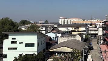 A multi-story building with a flat roof and a mix of residential and commercial structures in the background.