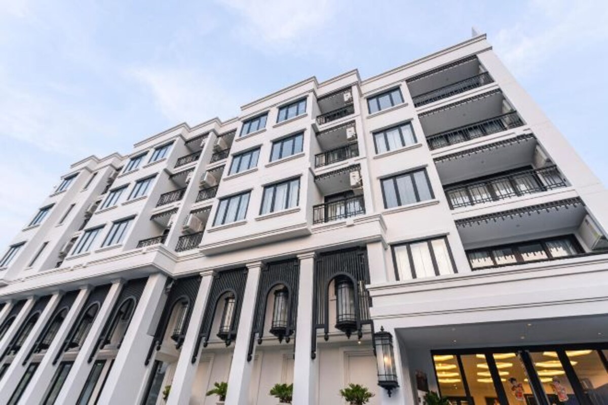 Un hotel de varios pisos con un diseño arquitectónico moderno, que cuenta con balcones y grandes ventanales.