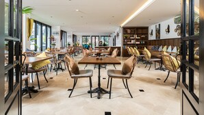 A spacious dining area with multiple tables and chairs, large windows, and a modern interior design. - Glory Boutique Suite (Chiang Mai)