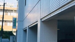 Ein Gebäude mit Kachelfassade und einem Schild mit der Aufschrift 'RA Kagoshima'.