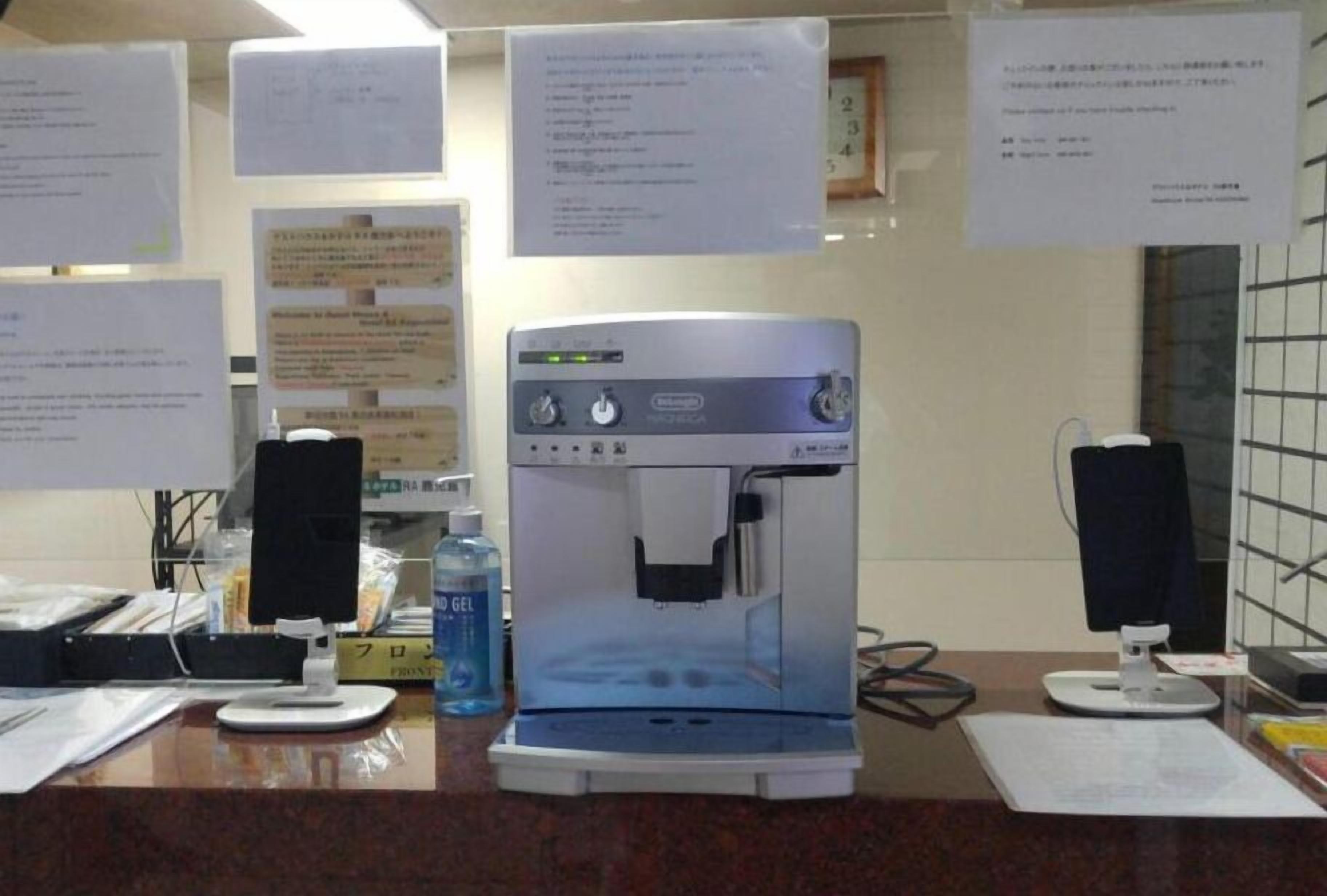 Een waterdispenser met twee speakers, een fles water en papieren op een aanrecht.