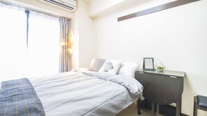 A hotel room with a bed, bedside table, and a small desk with a chair. - Garden Otsuka 704 (Tokyo)