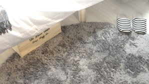 A pet bed with a label, a fluffy grey rug, and striped slippers. - Garden Otsuka 704 (Tokyo)