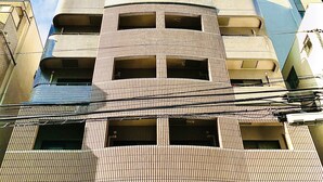 A multi-story building with a unique facade featuring a grid-like pattern and a central void. - Garden Otsuka 704 (Tokyo)