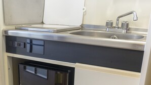 A compact kitchen with a built-in dishwasher, a sink, and a small oven. - Garden Otsuka 704 (Tokyo)