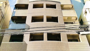 A multi-story building with a unique facade featuring a grid-like pattern and a central void. - Garden Otsuka 705 (Tokyo)