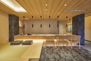 Um interior moderno com teto de madeira, um longo banco e uma mesa com cadeiras.