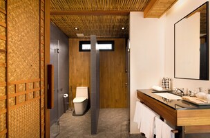 Une salle de bain moderne avec un plafond en bois, un grand miroir, un lavabo avec un meuble-vasque et des toilettes.