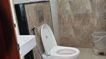 Un baño moderno con inodoro, bidé y lavabo.