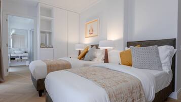 Une chambre d’hôtel avec deux lits, une salle de bain et un couloir.